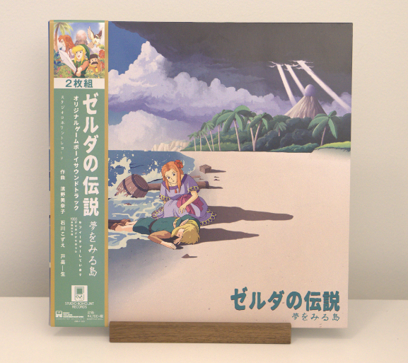 A record cover from The legend of Zelda: Links awakening. It shows the hero washed up on shore. A woman trying to help him.